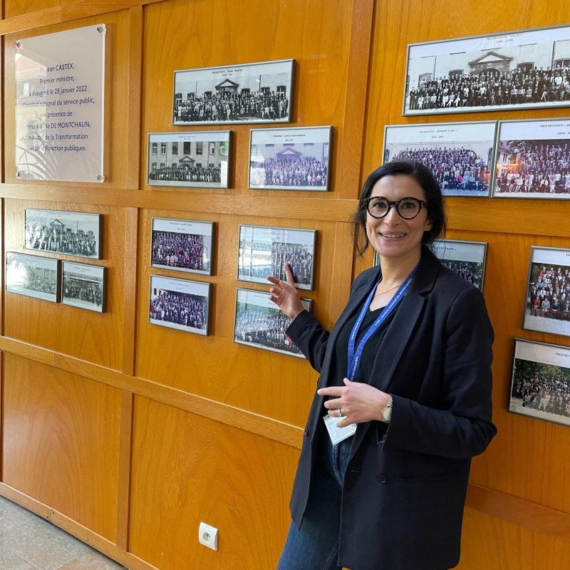  Mme Aïda HAMDI, à l'INSP, à Strasbourg, devant les photos de promotion.